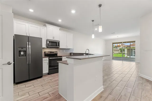 a kitchen with refrigerator and microwave