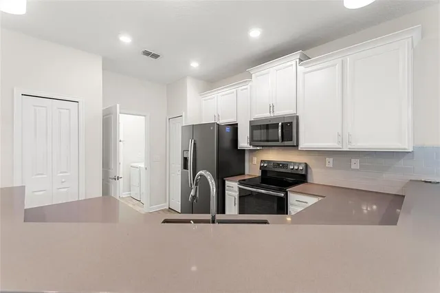a kitchen with stainless steel appliances granite countertop a refrigerator and a stove