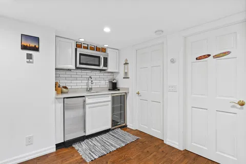 a kitchen with granite countertop cabinets stainless steel appliances and a wooden floor