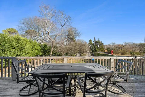 a view of a wooden table and chairs on the roof deck