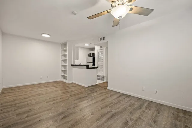 a view of a kitchen with a sink and dishwasher a refrigerator with wooden floor