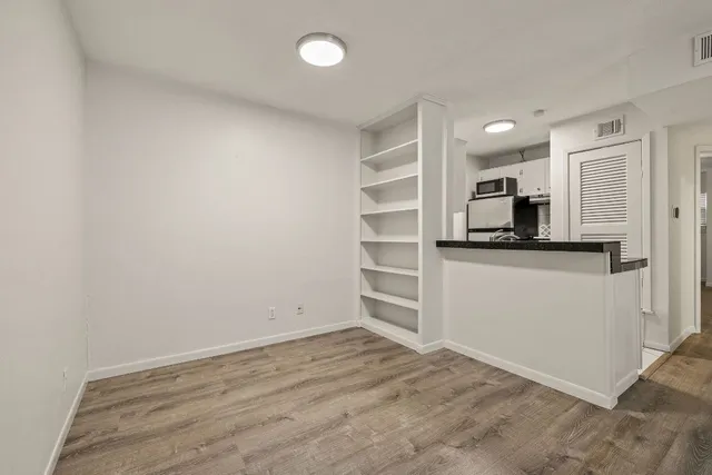a view of a kitchen with wooden floor and electronic appliances