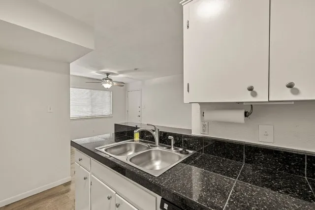 a bathroom with a granite countertop sink and white cabinets