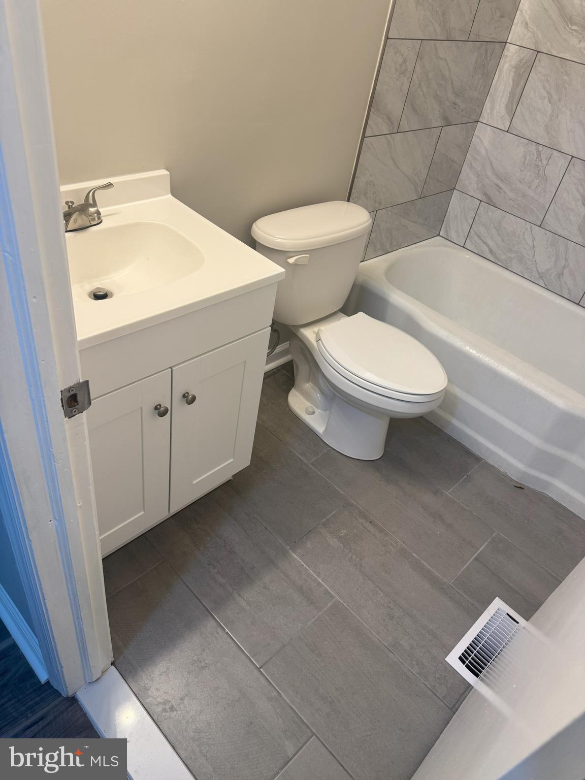 408 Cherry Hill Road Street, MD 21154 - Photo 12 of 17 a white toilet sitting next to a bathroom sink and vanity