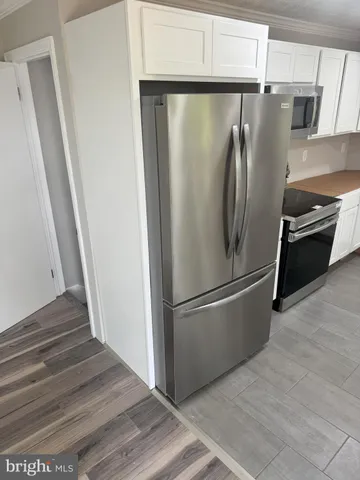a metallic refrigerator freezer sitting in a kitchen