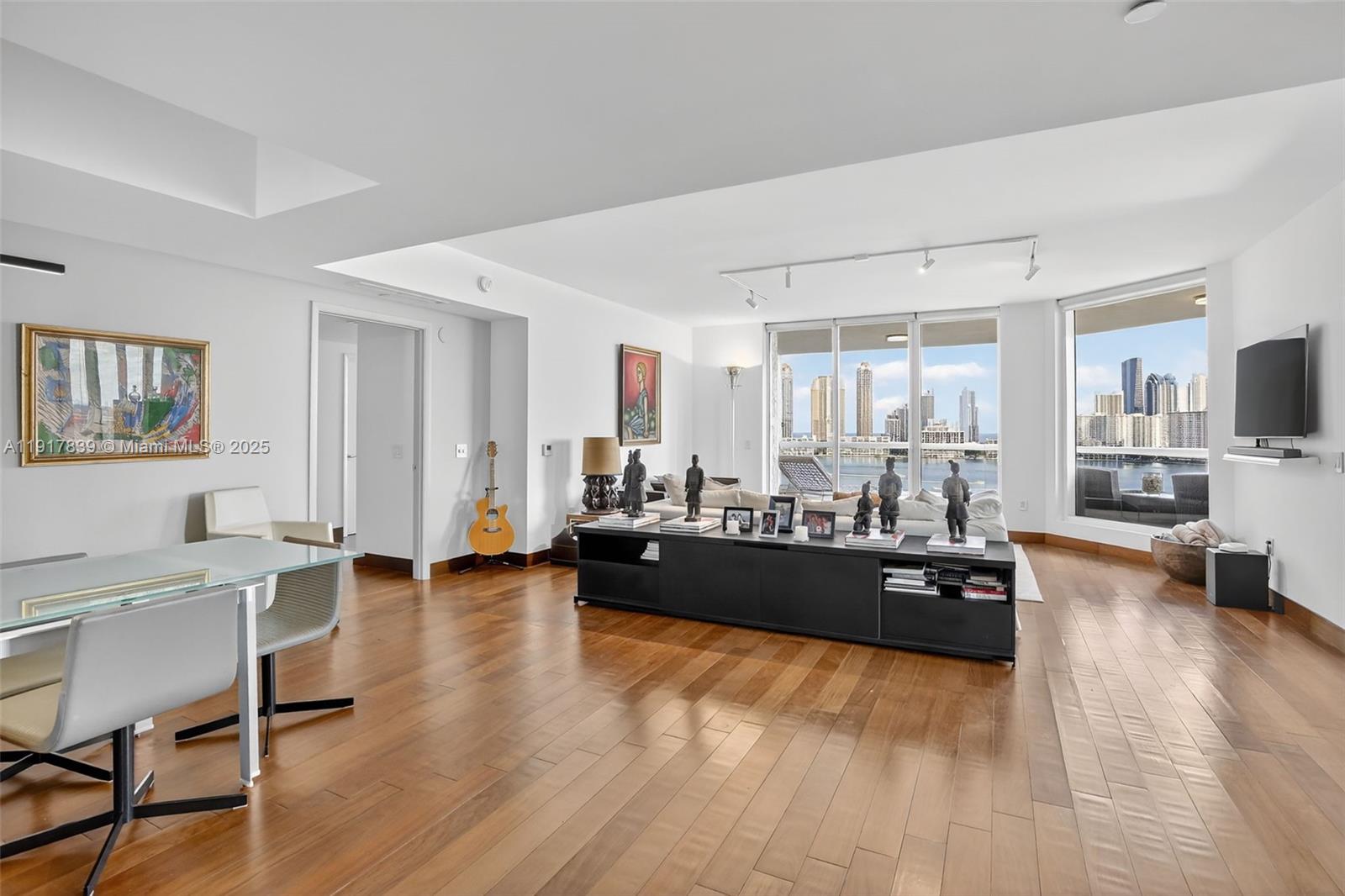 6000 Island Boulevard, Unit 1208 Aventura, FL 33160 - Photo 1 of 50 a living room with furniture and a wooden floor