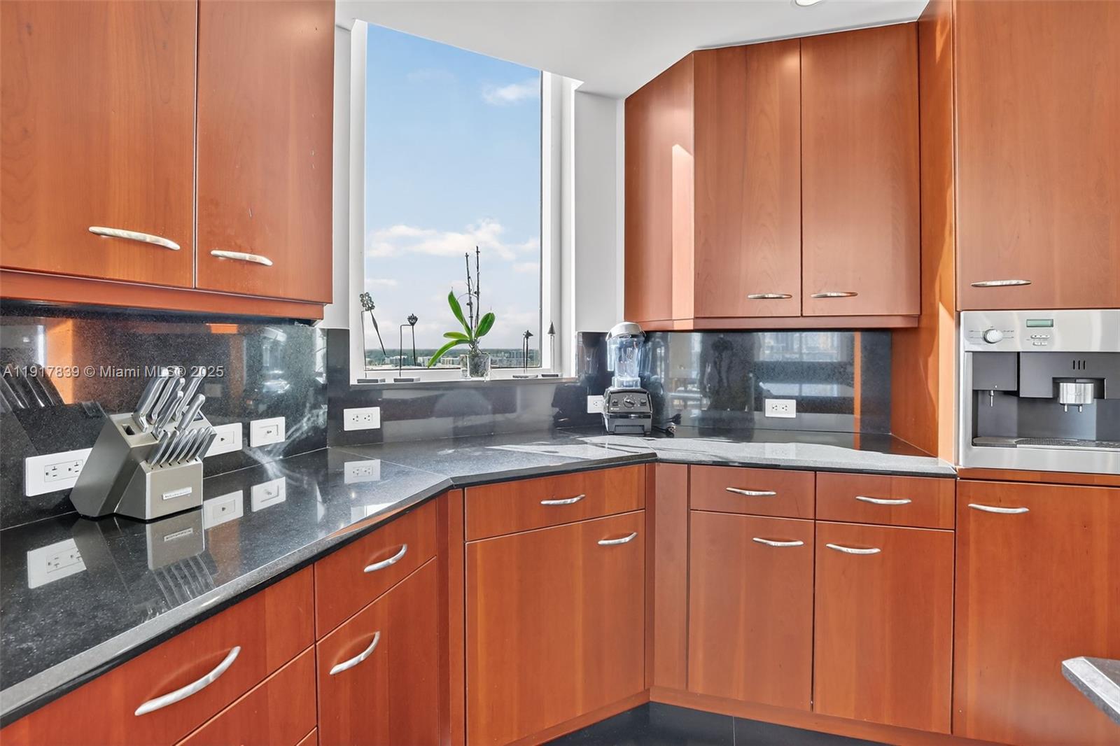 6000 Island Boulevard, Unit 1208 Aventura, FL 33160 - Photo 14 of 50 a kitchen with granite countertop wooden cabinets a sink and dishwasher