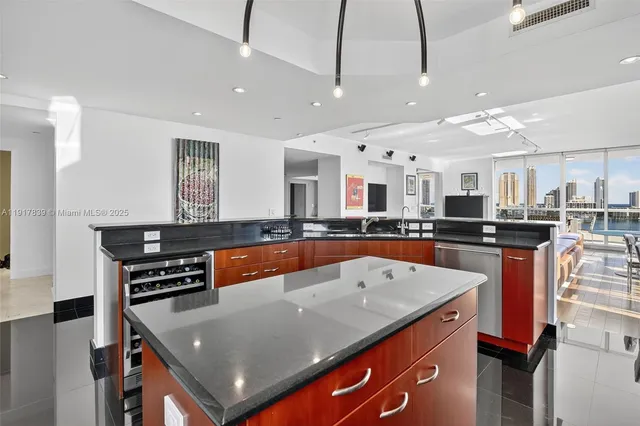 a large kitchen with stainless steel appliances granite countertop a sink a stove and a refrigerator