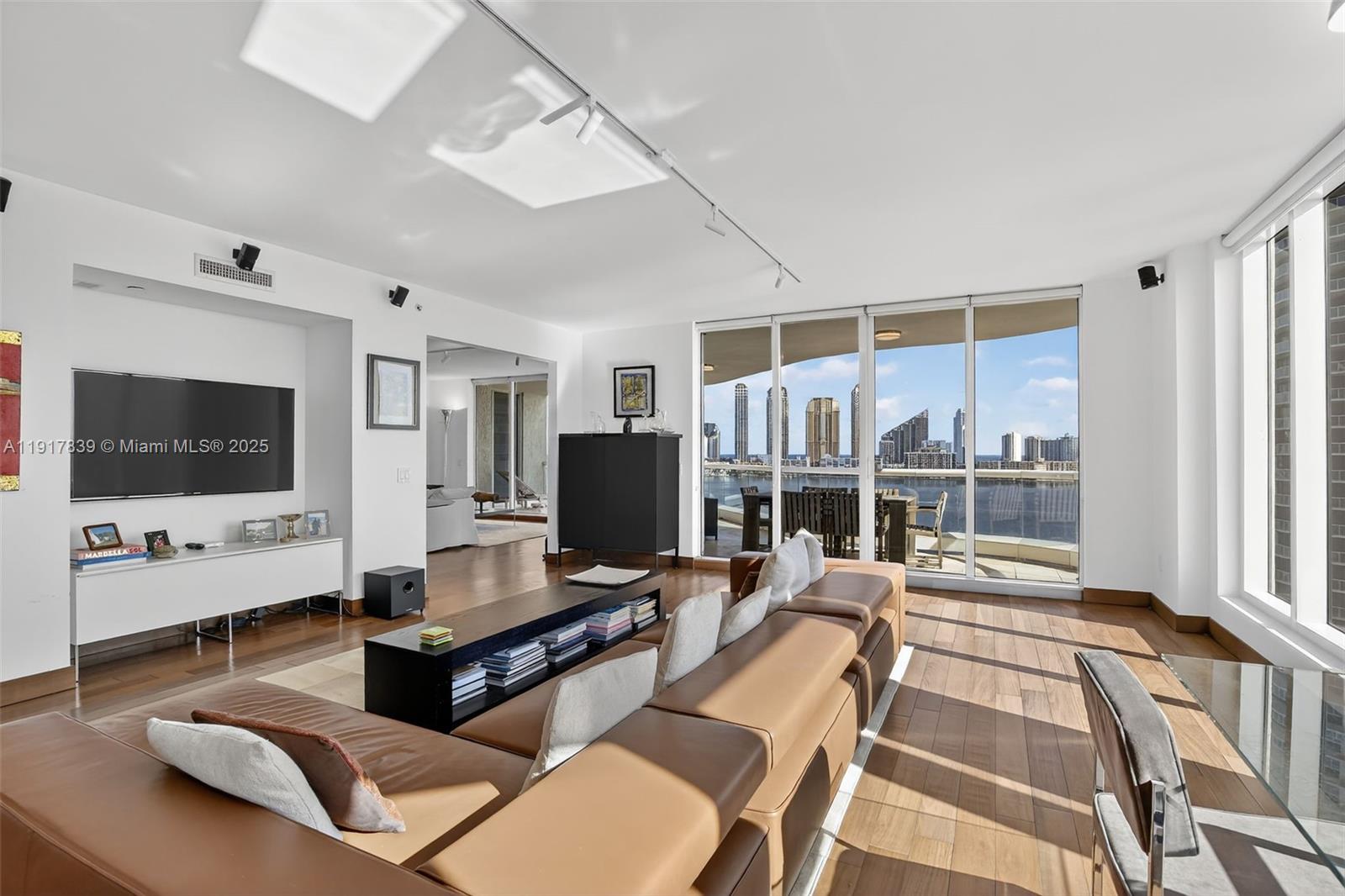 6000 Island Boulevard, Unit 1208 Aventura, FL 33160 - Photo 2 of 50 a living room with furniture flat screen tv and a large window