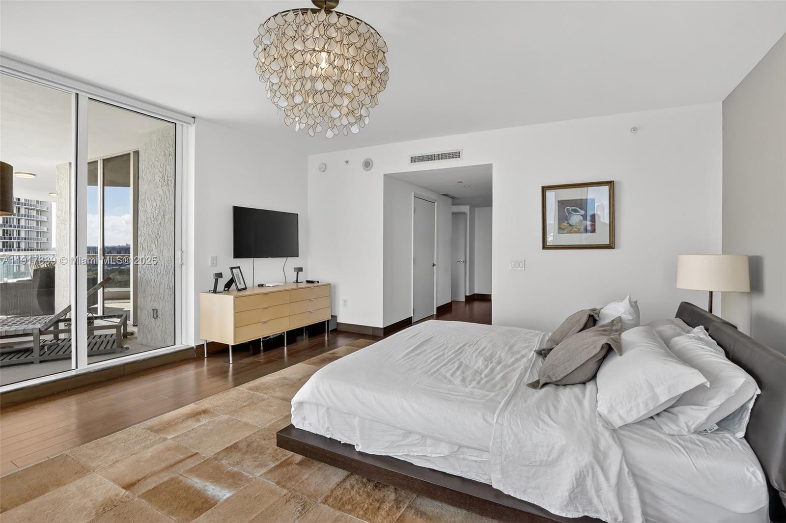 6000 Island Boulevard, Unit 1208 Aventura, FL 33160 - Photo 22 of 50 a bedroom with a bed and a chandelier