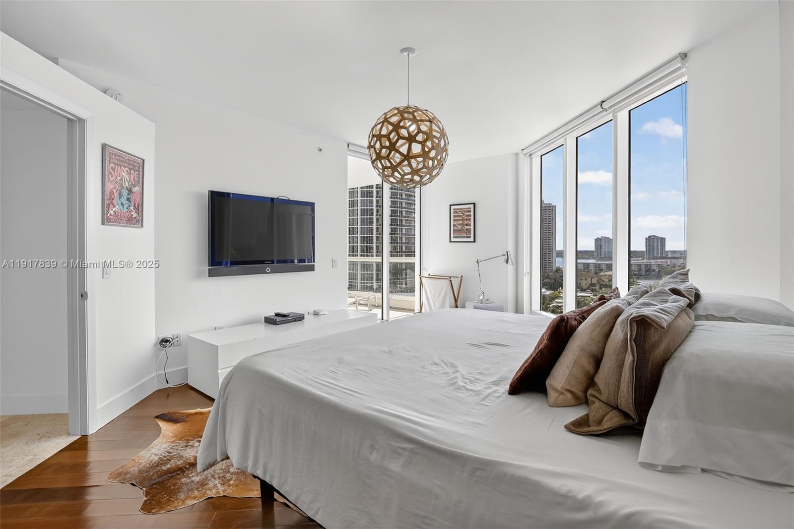 6000 Island Boulevard, Unit 1208 Aventura, FL 33160 - Photo 28 of 50 a spacious bedroom with a bed and a flat screen tv