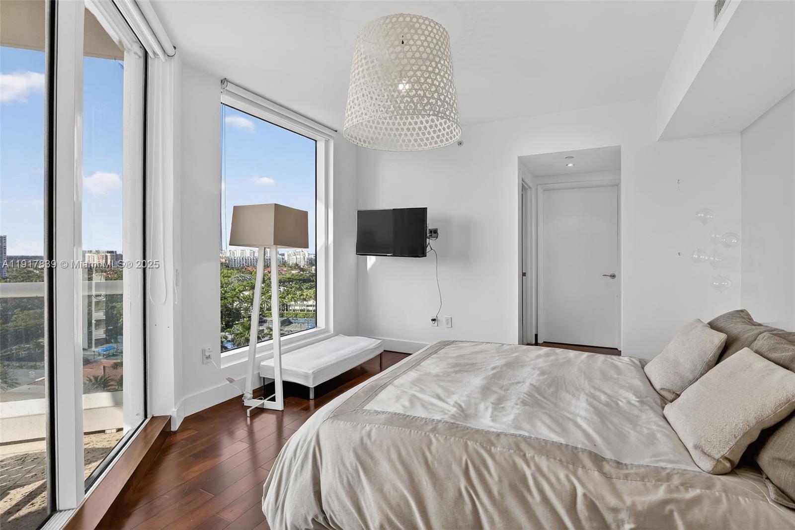 6000 Island Boulevard, Unit 1208 Aventura, FL 33160 - Photo 35 of 50 a bedroom with a bed and a flat tv screen next to a window