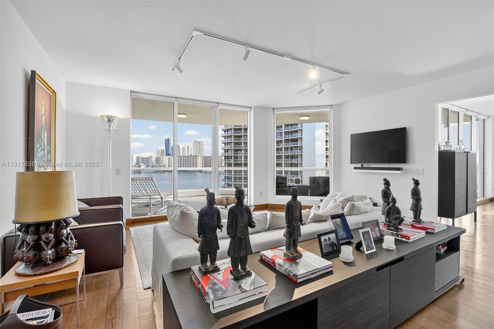 6000 Island Boulevard, Unit 1208 Aventura, FL 33160 - Photo 7 of 50 a living room with furniture and a flat screen tv