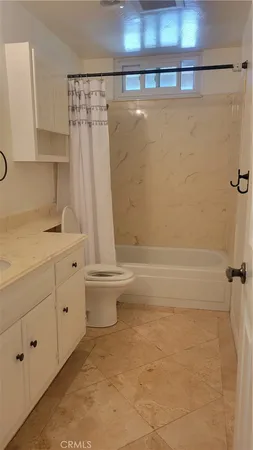 a bathroom with a granite countertop sink a toilet and shower
