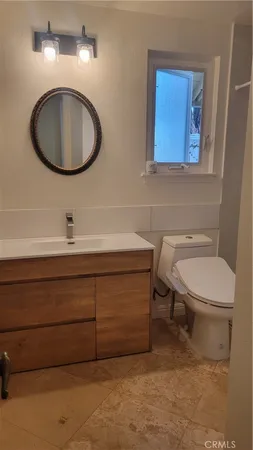 a bathroom with a toilet a sink and mirror