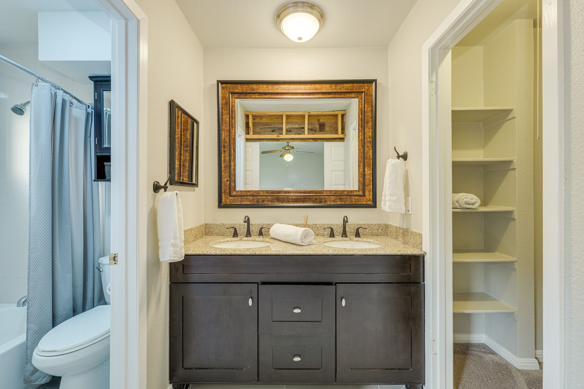 4815 Transit Circle Austin, TX 78727 - Photo 24 of 35 Double vanity with granite-style countertop, dual undermount sinks, and dark wood-finish cabinetry