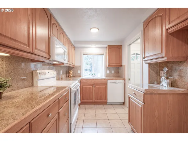a kitchen with a sink a stove cabinets and wooden floor
