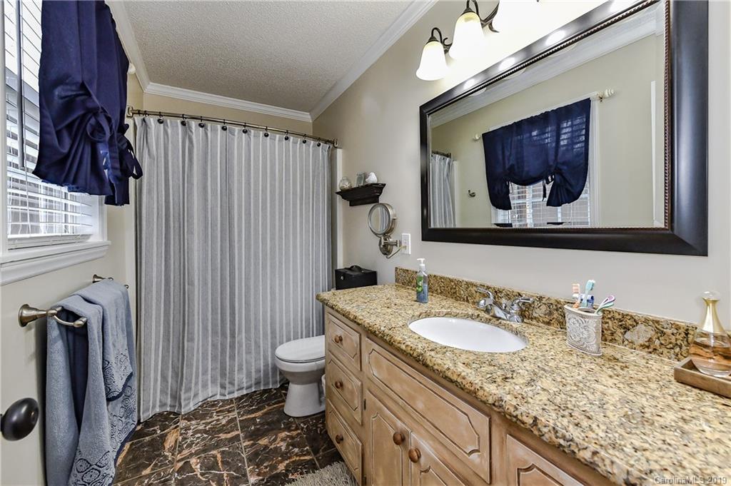 1108 Pinewood Road Rock Hill, SC 29730 - Photo 19 of 26 a bathroom with a granite countertop sink a toilet and a mirror