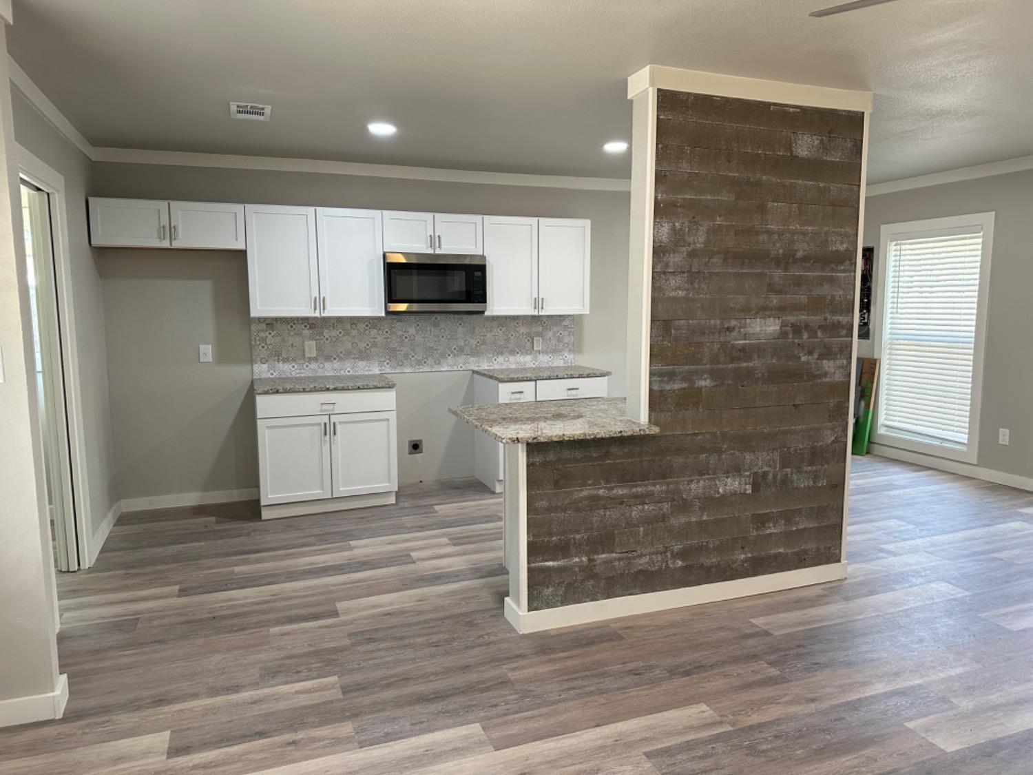 3408 29th Street Lubbock, TX 79410 - Photo 2 of 19 a kitchen with stainless steel appliances granite countertop a stove top oven a sink and a microwave