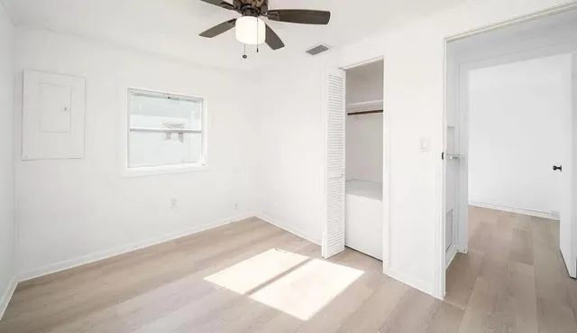 an empty room with fan and windows