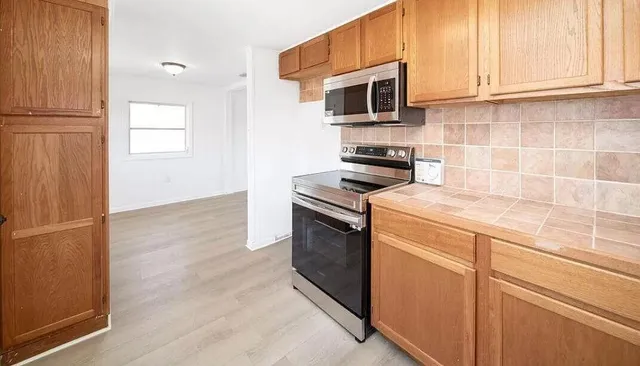 a kitchen with stainless steel appliances a stove microwave and sink