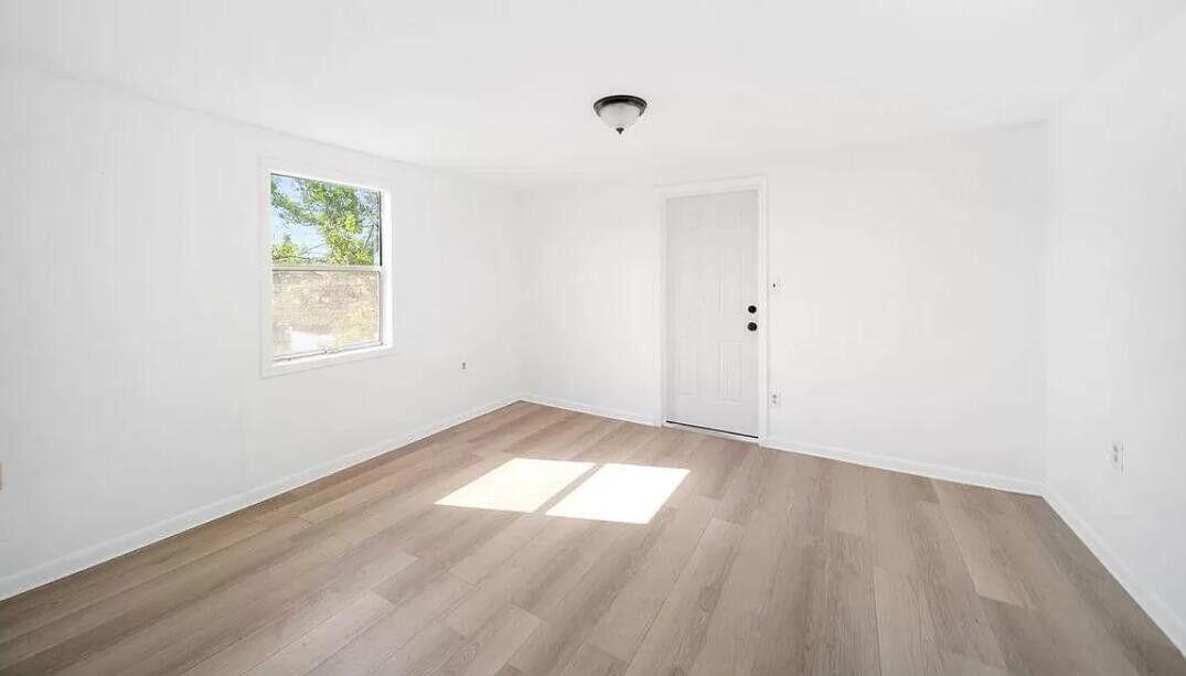 1520 Hunter Road, Unit A Okeechobee, FL 34974 - Photo 7 of 20 an empty room with wooden floor and windows