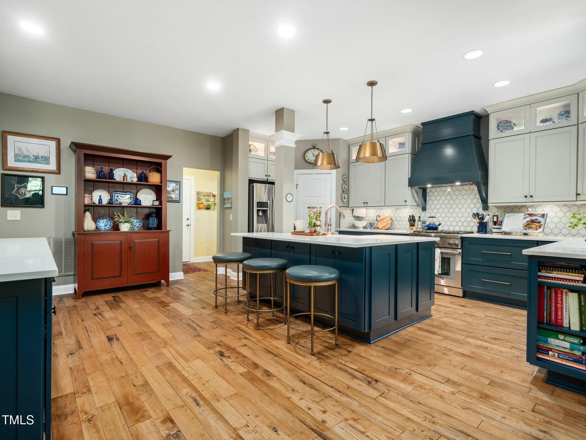 4210 Falls River Avenue Raleigh, NC 27614 - Photo 11 of 53 a room with kitchen island stainless steel appliances kitchen island granite countertop a sink and cabinets