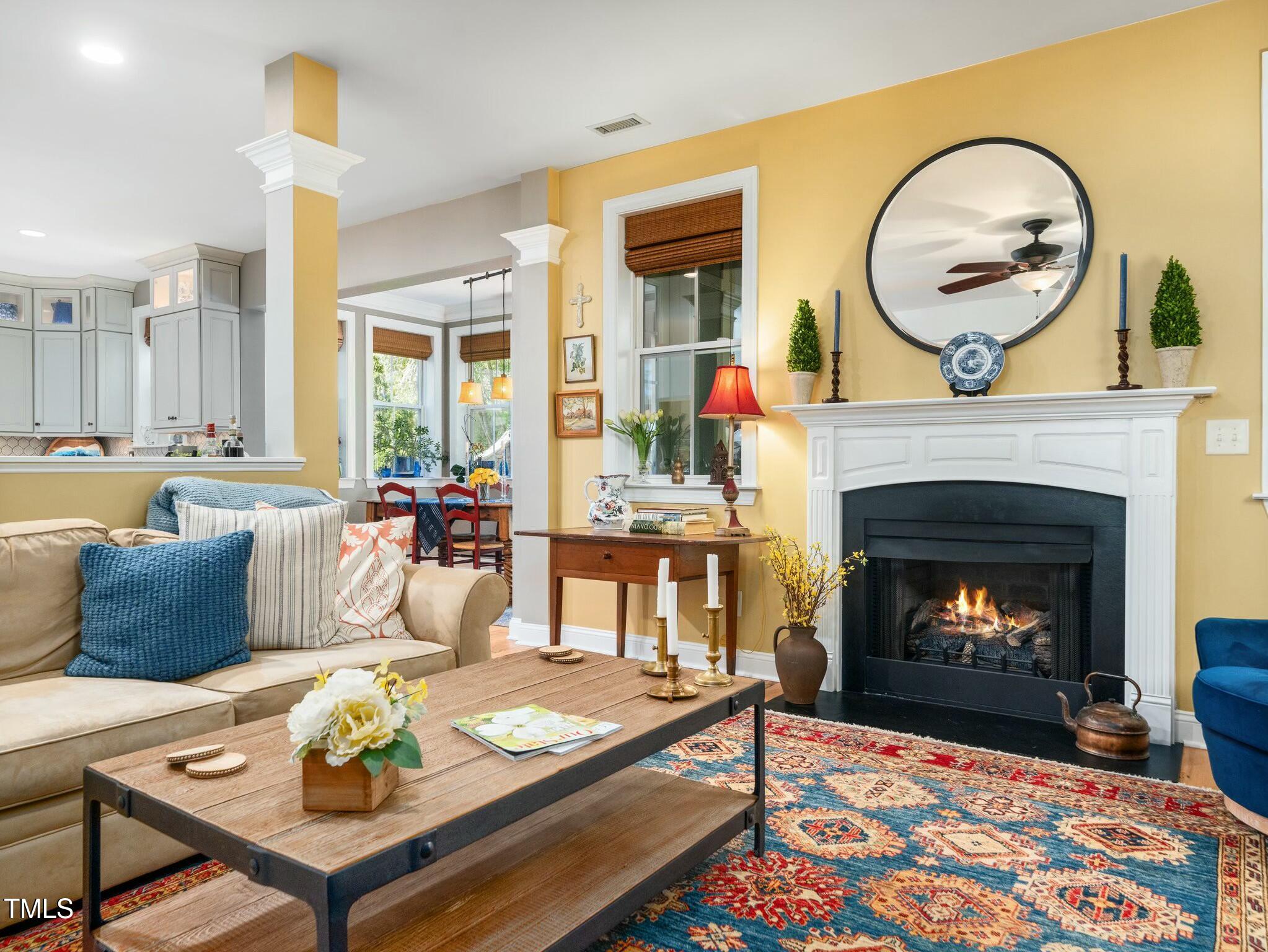 4210 Falls River Avenue Raleigh, NC 27614 - Photo 16 of 53 a living room with furniture a fireplace and a large window