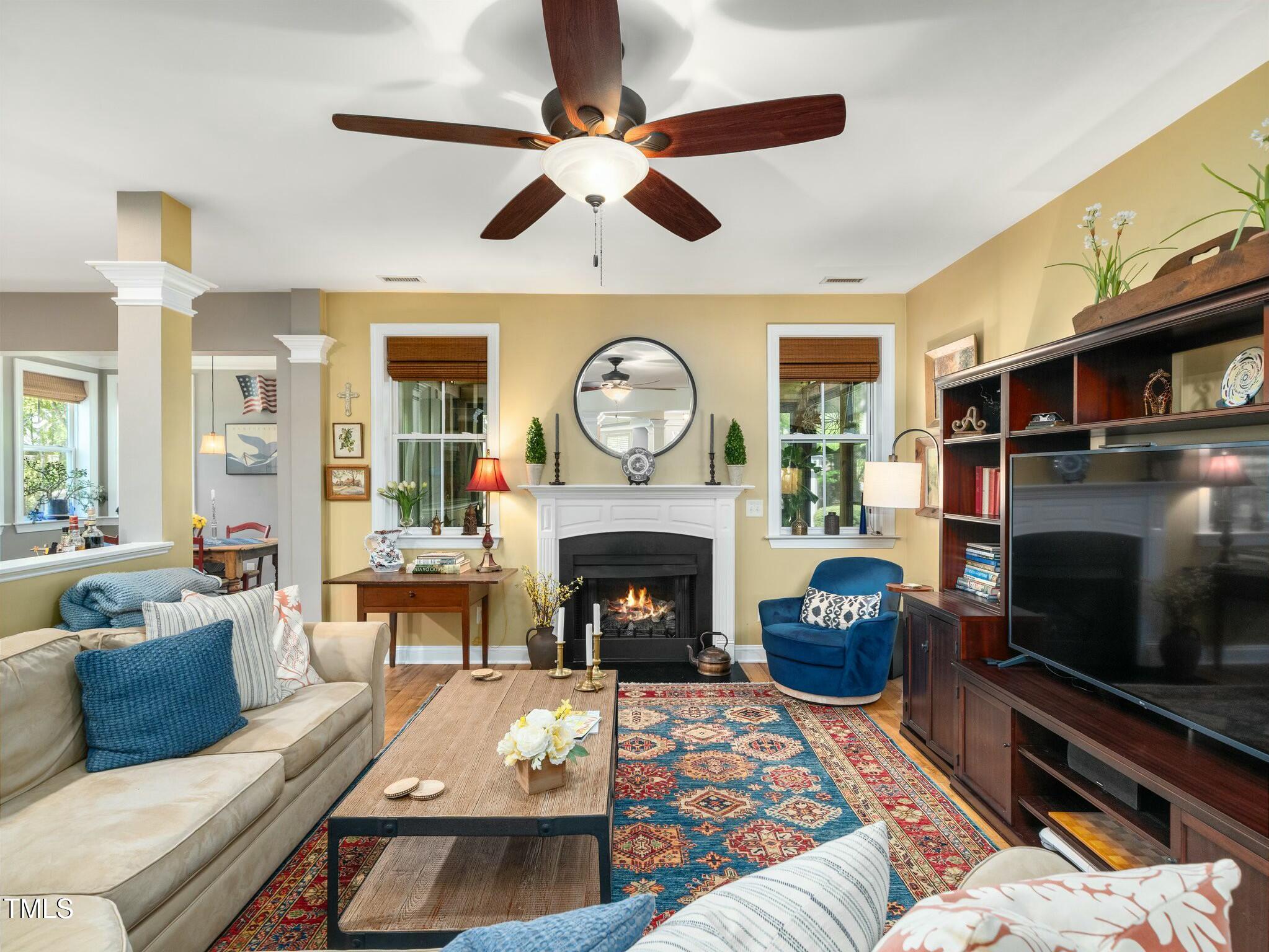 4210 Falls River Avenue Raleigh, NC 27614 - Photo 17 of 53 a living room with furniture a fireplace and a flat screen tv