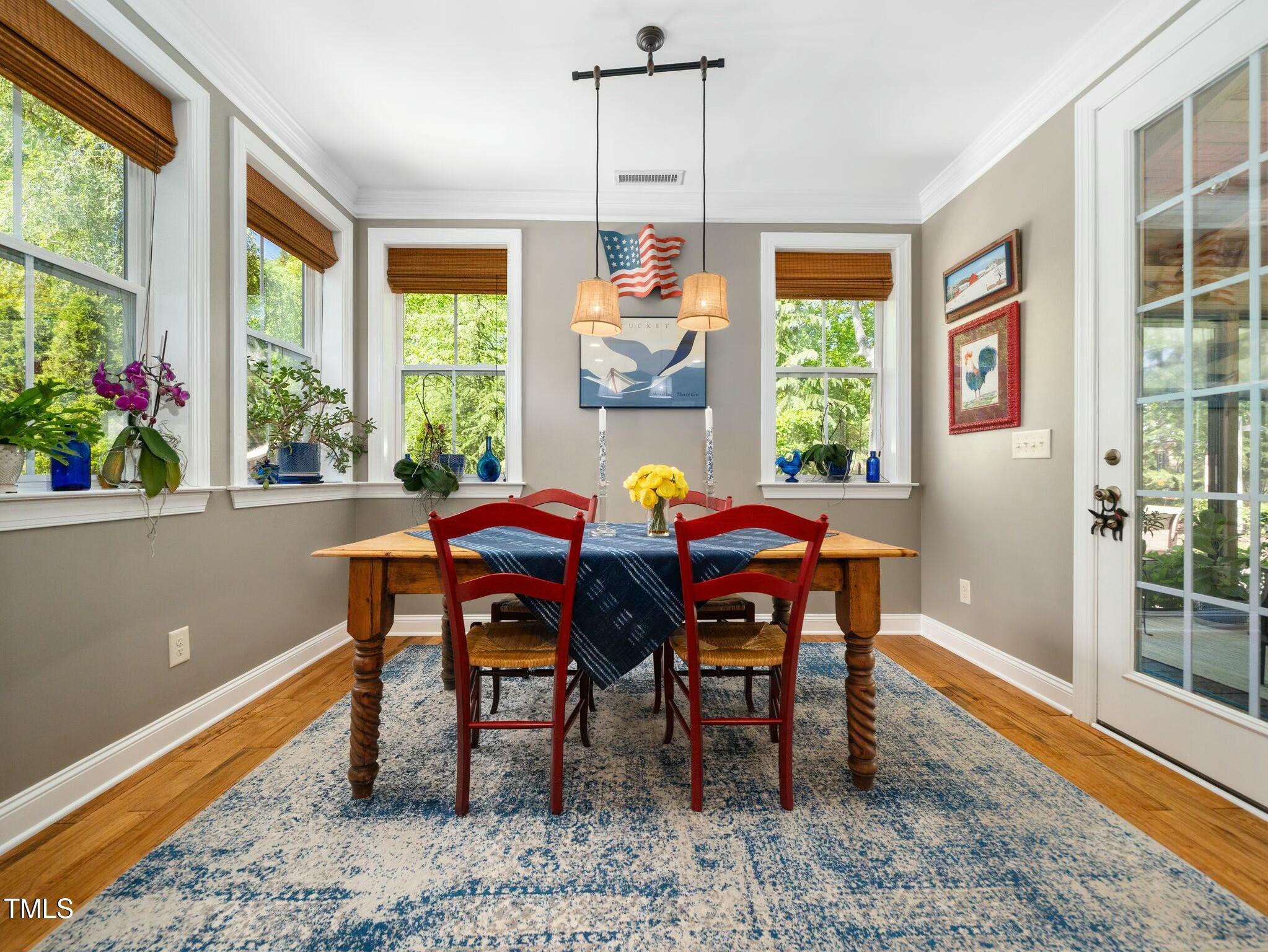 4210 Falls River Avenue Raleigh, NC 27614 - Photo 20 of 53 a dining room with furniture a rug and a potted plant