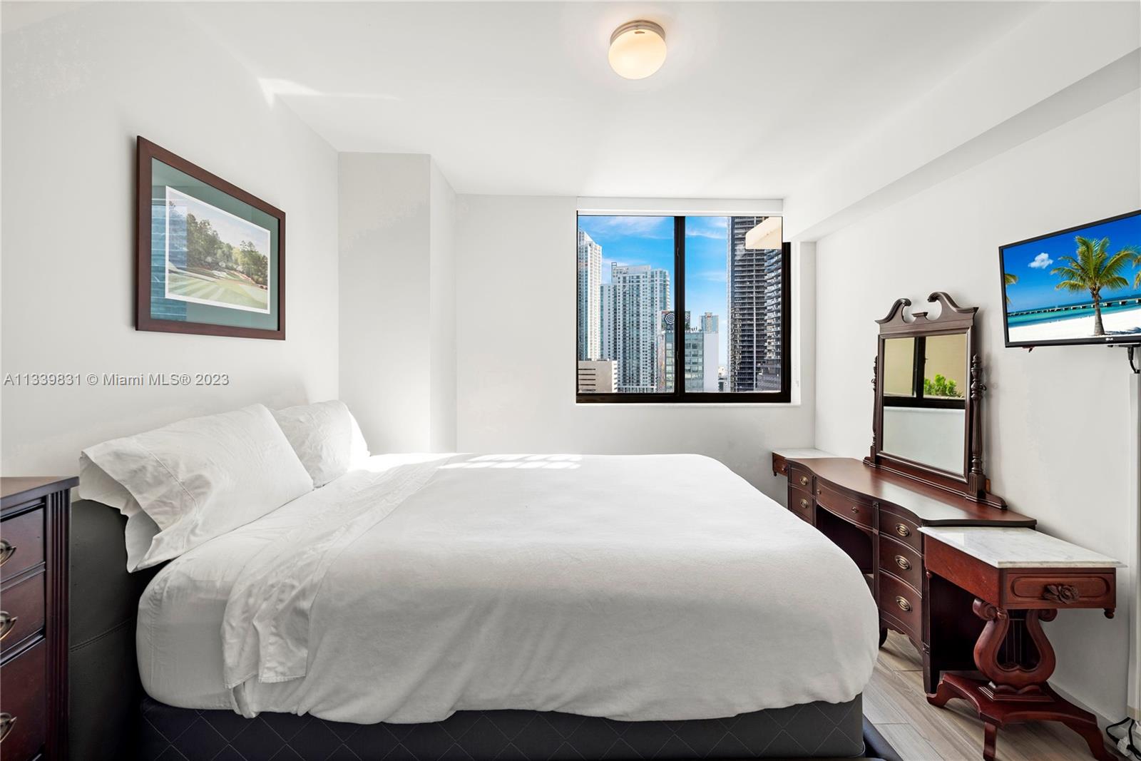 999 Southwest 1st Avenue, Unit 1811 Miami, FL 33130 - Photo 12 of 36 a bedroom with a bed and wooden floor