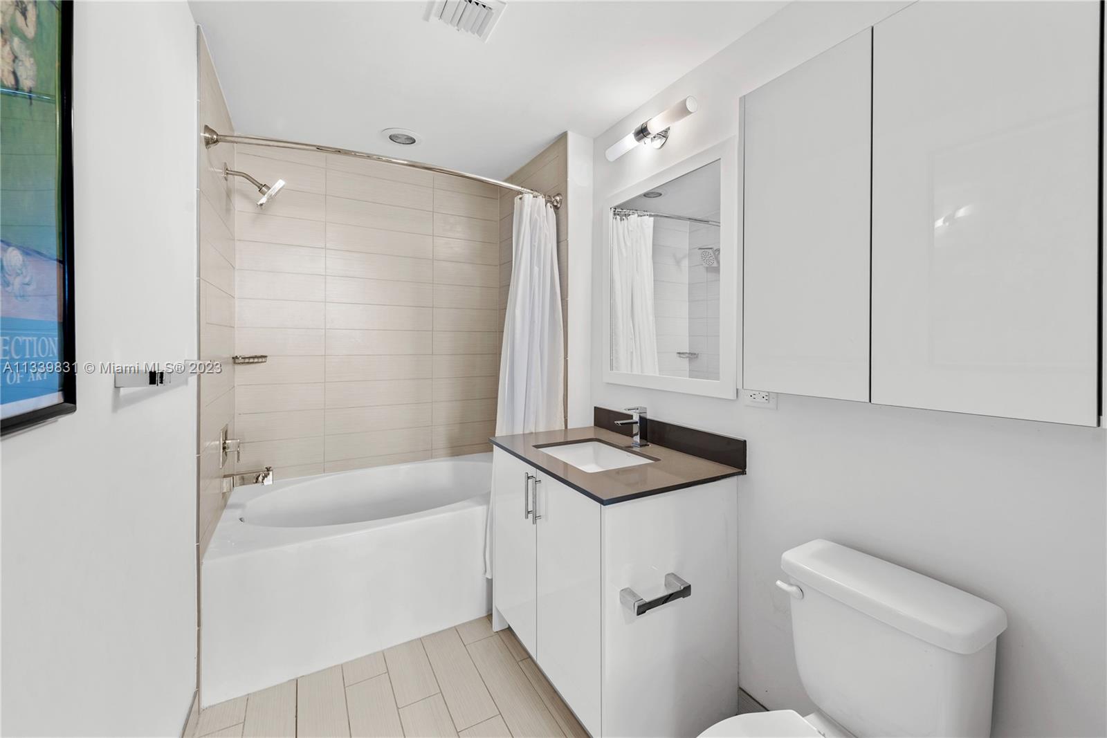 999 Southwest 1st Avenue, Unit 1811 Miami, FL 33130 - Photo 15 of 36 a bathroom with a sink a toilet and shower