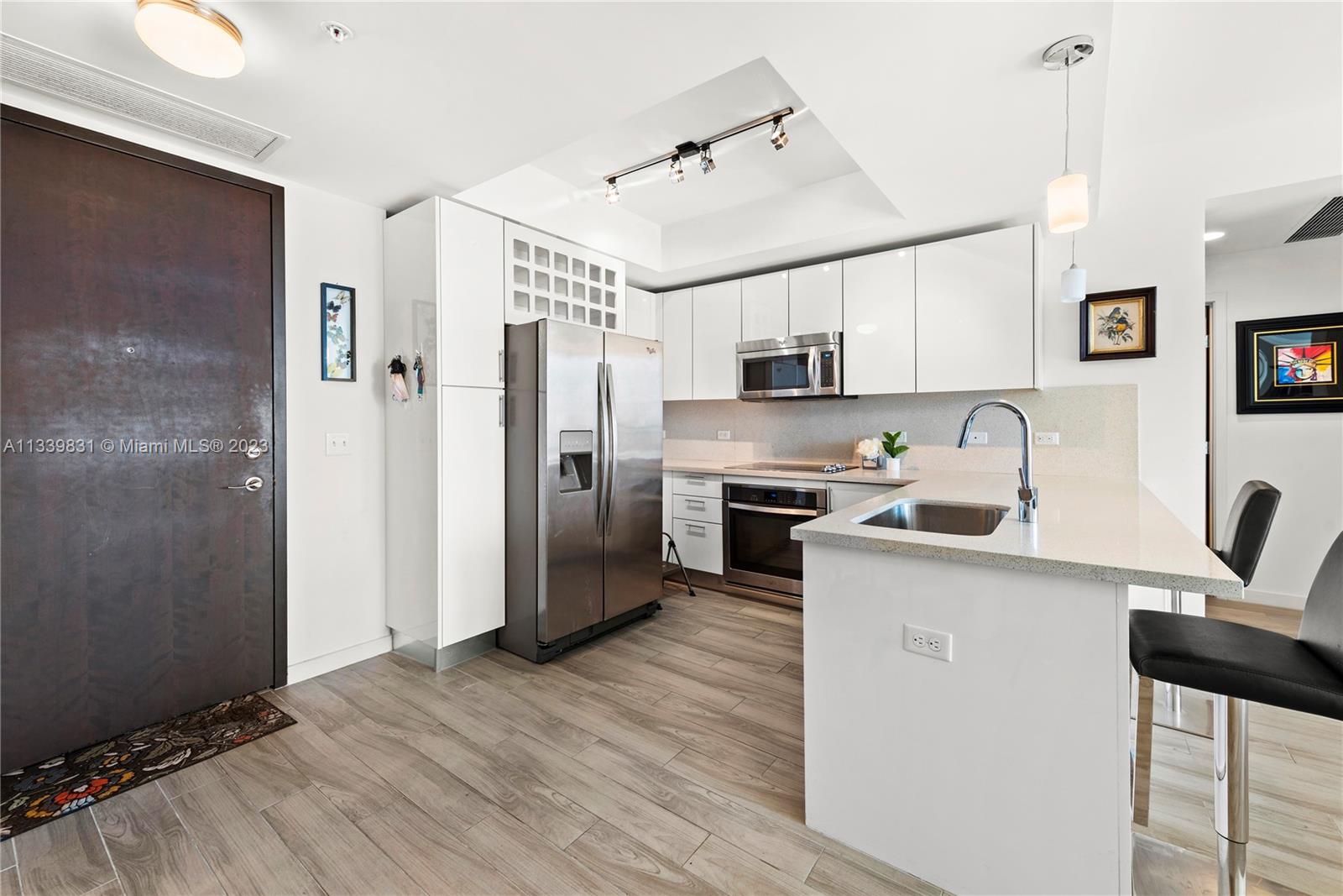 999 Southwest 1st Avenue, Unit 1811 Miami, FL 33130 - Photo 4 of 36 a kitchen with stainless steel appliances a refrigerator sink and microwave
