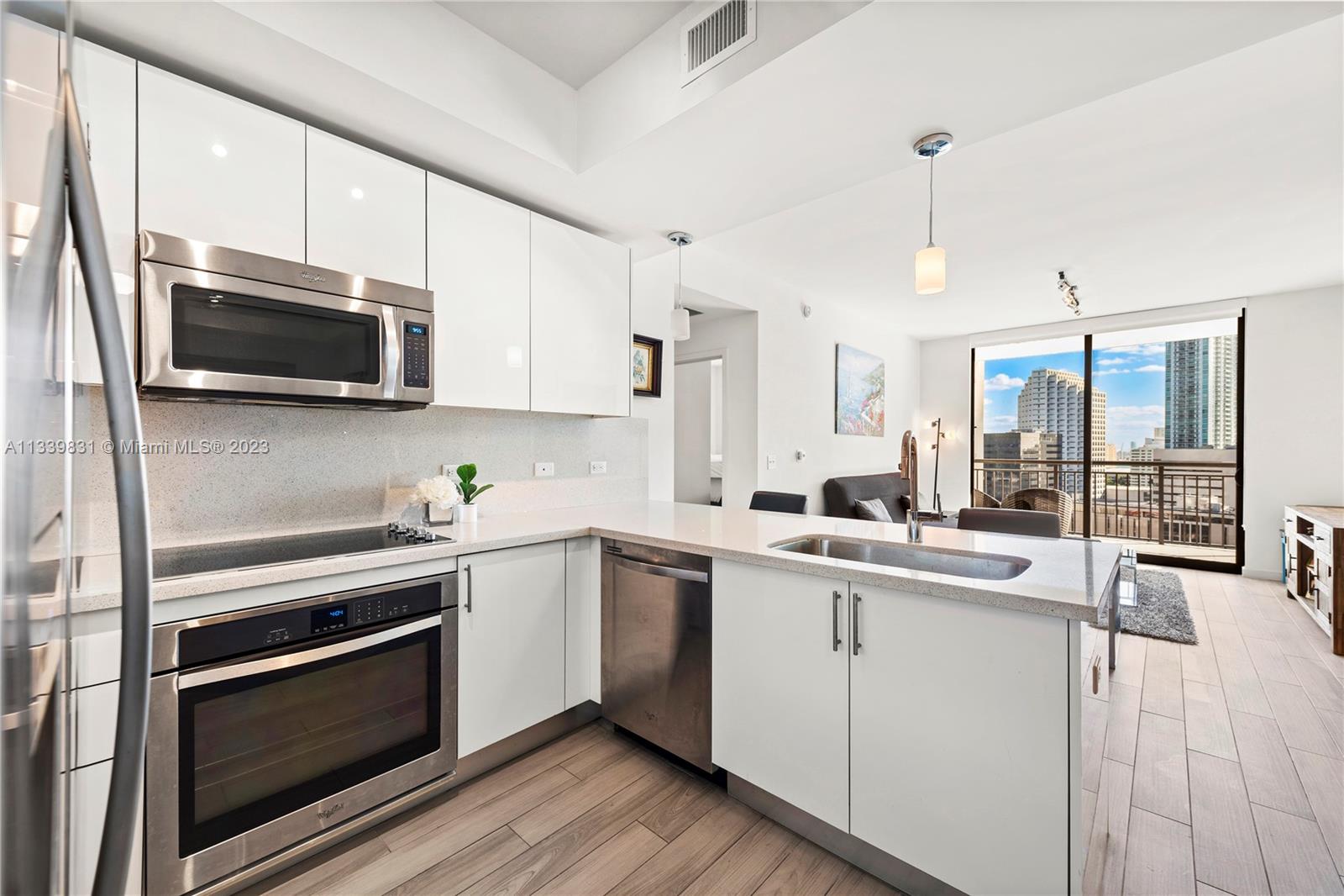 999 Southwest 1st Avenue, Unit 1811 Miami, FL 33130 - Photo 5 of 36 a kitchen with a sink stove and microwave
