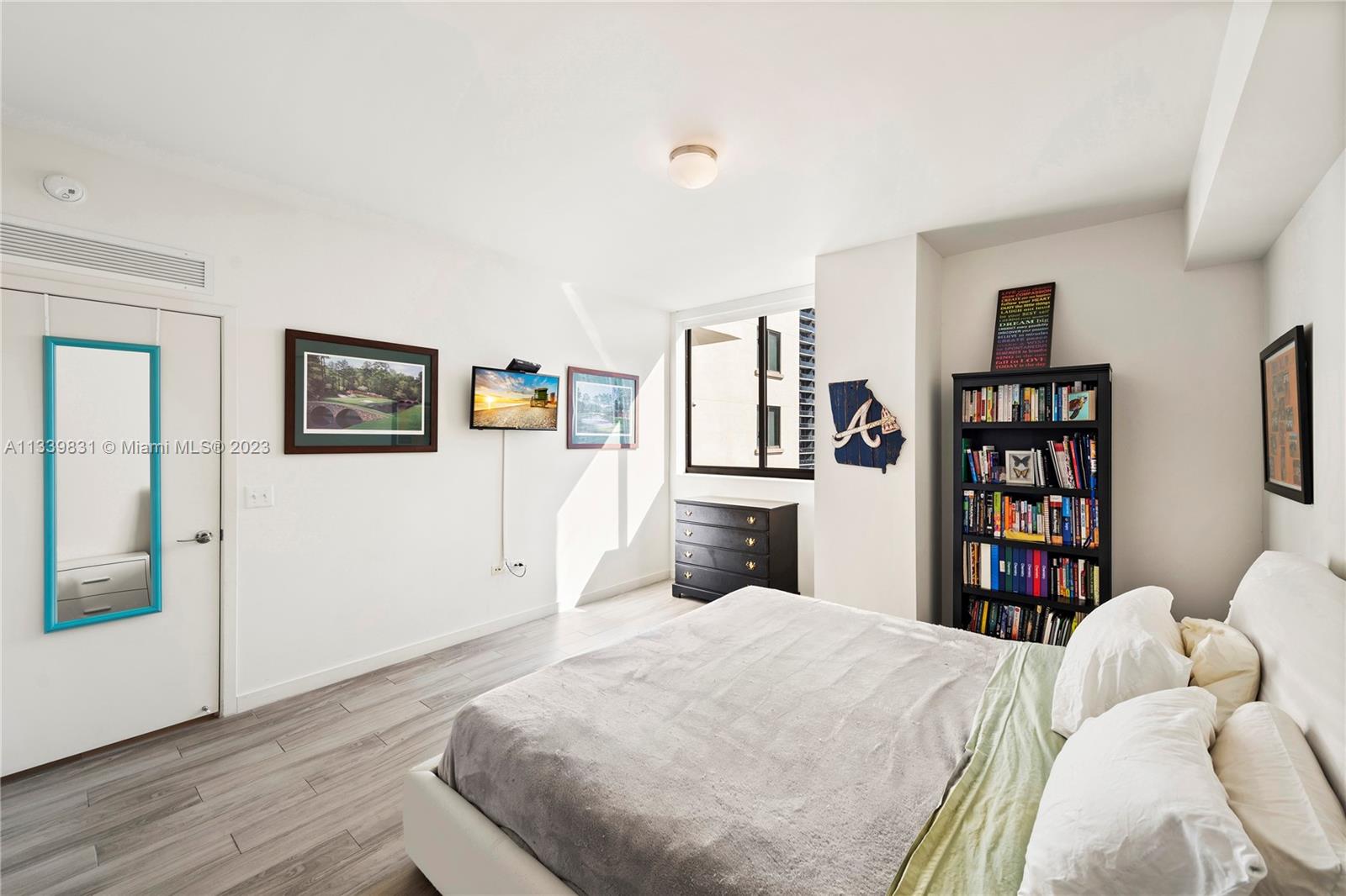 999 Southwest 1st Avenue, Unit 1811 Miami, FL 33130 - Photo 10 of 36 a bedroom with a large bed and a book shelf