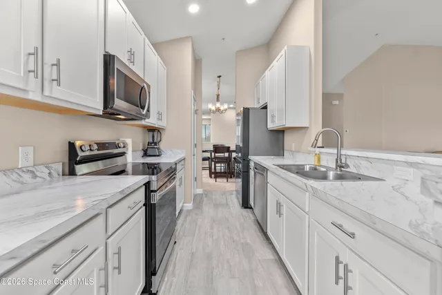 a large kitchen with stainless steel appliances granite countertop a lot of counter space and wooden floors