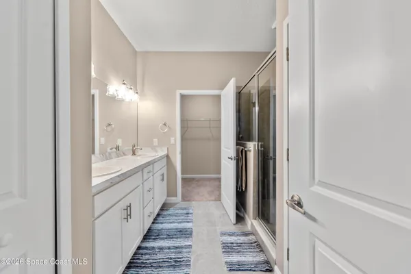 a bathroom with a double vanity sink and mirror with shower