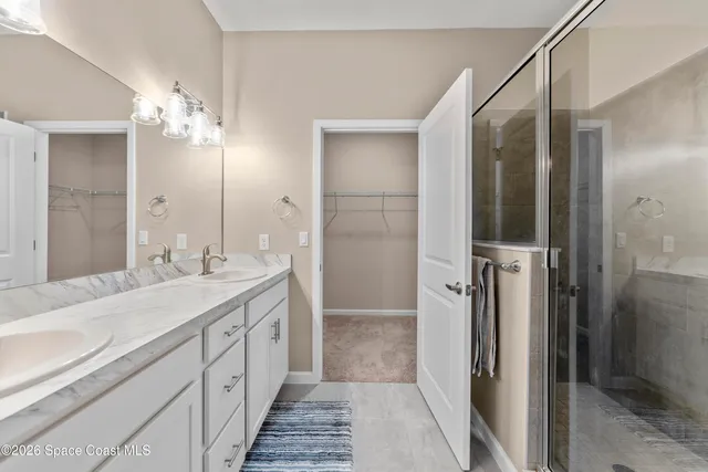 a bathroom with a double vanity sink a mirror and a shower