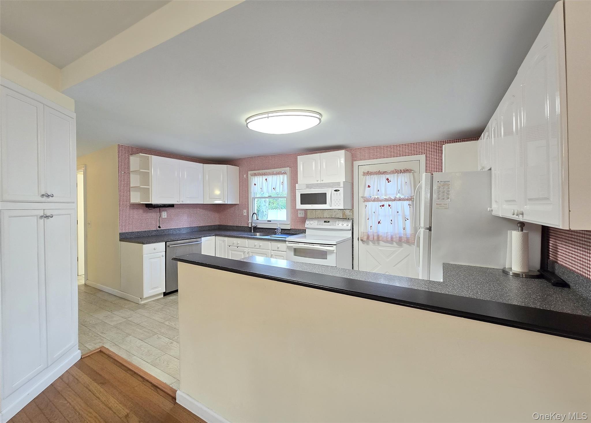 170 Forge Road Calverton, NY 11933 - Photo 11 of 23 a kitchen with stainless steel appliances granite countertop a sink a stove and a wooden floors