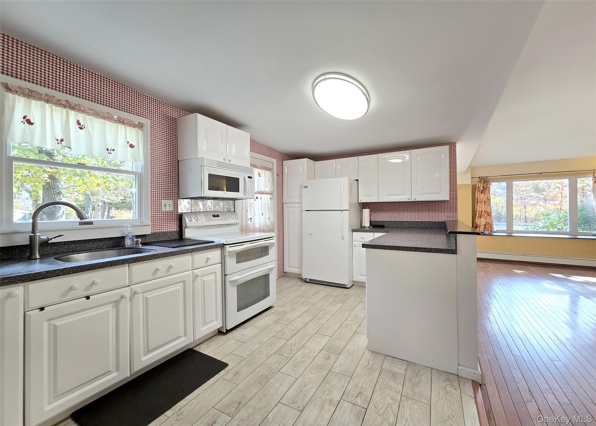 170 Forge Road Calverton, NY 11933 - Photo 9 of 23 a kitchen with granite countertop white cabinets and white appliances