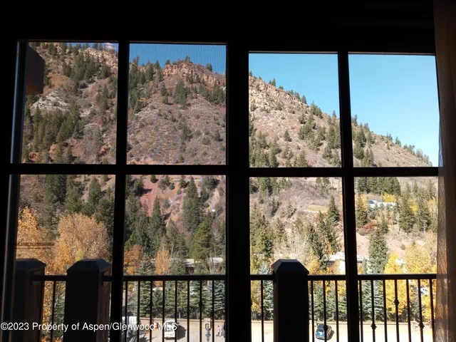 a view of a glass door and a yard from a balcony