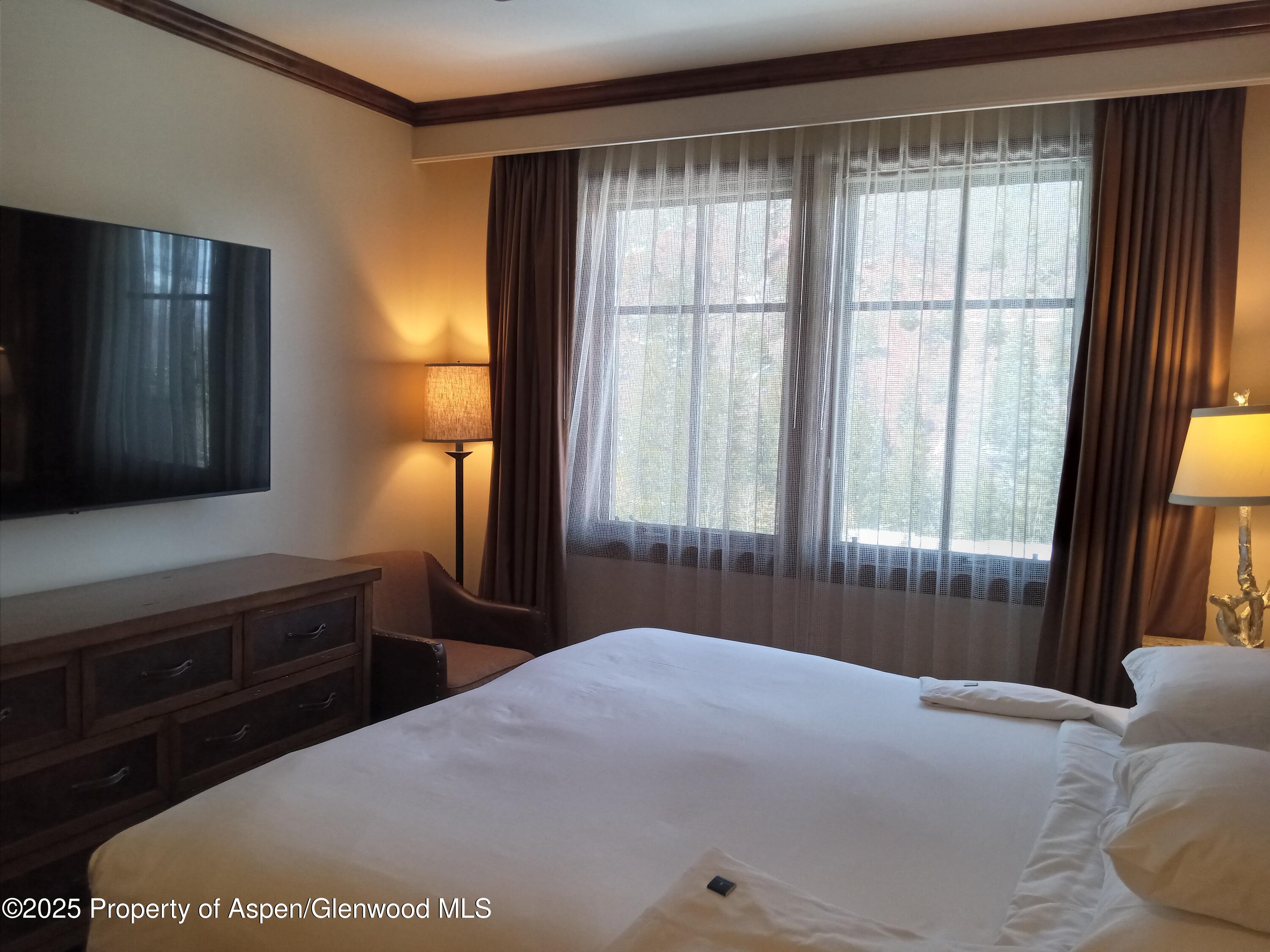 39 Boomerang Road, Unit 8411 21 Aspen, CO 81611 - Photo 24 of 25 a bedroom with a bed and a dresser next to a window