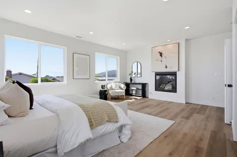a bedroom with furniture a fireplace and a window