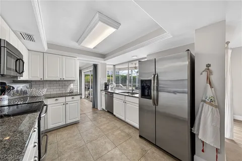 a kitchen with granite countertop a stove a sink and a microwave