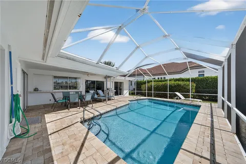 a view of a house with swimming pool and furniture