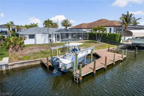 an aerial view of a house with swimming pool and a yard