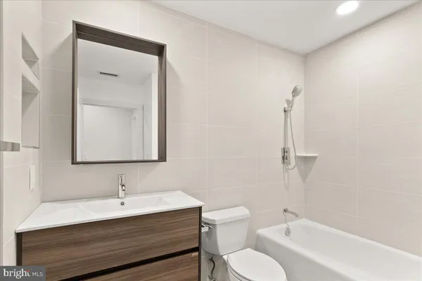 a bathroom with a sink vanity mirror and toilet