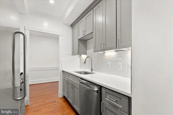 a kitchen with stainless steel appliances granite countertop a sink and a refrigerator