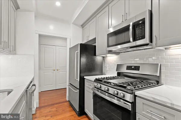 a kitchen with stainless steel appliances granite countertop a stove microwave and refrigerator