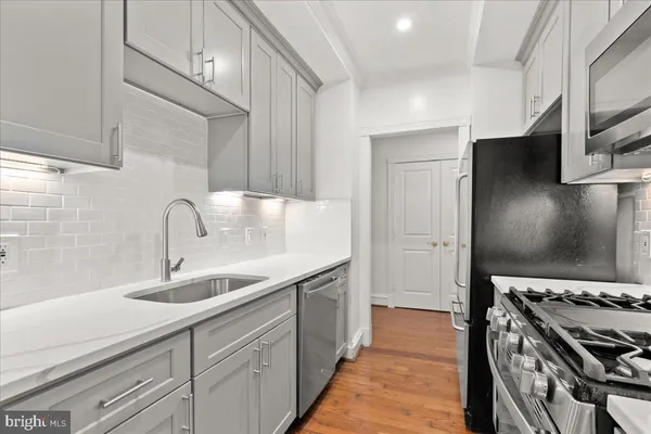 a kitchen with stainless steel appliances granite countertop a sink stove and refrigerator